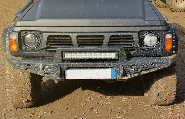 Automobile in a countryside landscape with a mud road offroad x suv automobile with ditry body