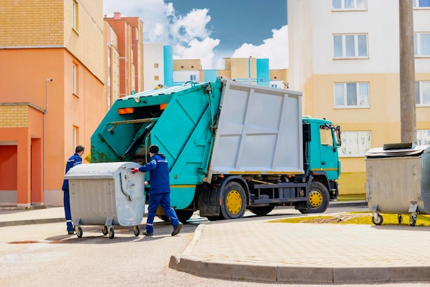 An automobile garbage truck collects garbage in residential\
areas of a modern city men load a metal container with garbage into\
a car for collecting and transporting garbage