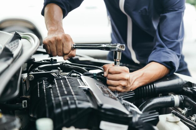 Automobile mechanic repairman hands repairing a car engine
automotive workshop with a wrench car service and maintenancerepair
service