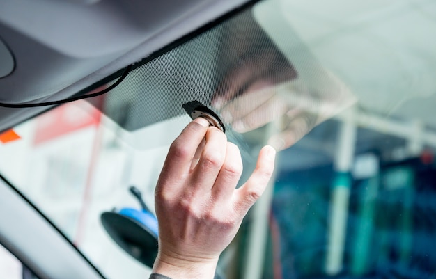 Automobile special workers remove old windscreen or windshield of a car