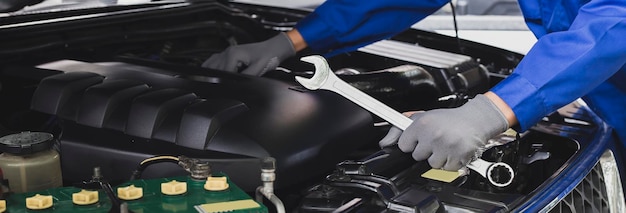 Automonteur bezig met automotor, auto-onderhoudsconcept.