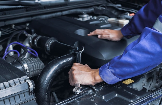 Automonteur bezig met automotor, auto-onderhoudsconcept.