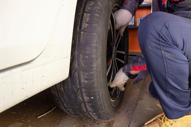 Automonteur bezig met het vervangen van nieuwe banden Reparatie van autoremmen in de garage