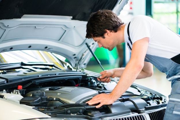 Automonteur die in de workshop van de autodienst werkt