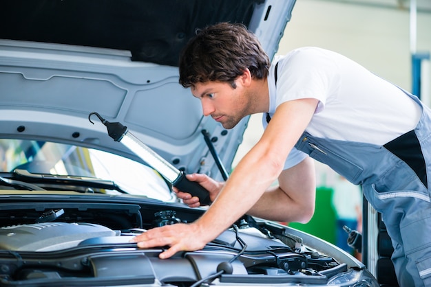 Foto automonteur die in de workshop van de autodienst werkt