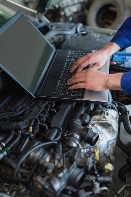 Foto automonteur die laptop met behulp van