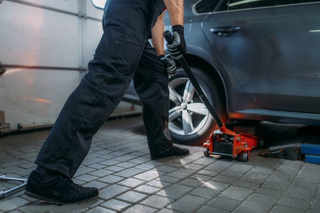 Automonteur krikken de auto in bandenservice