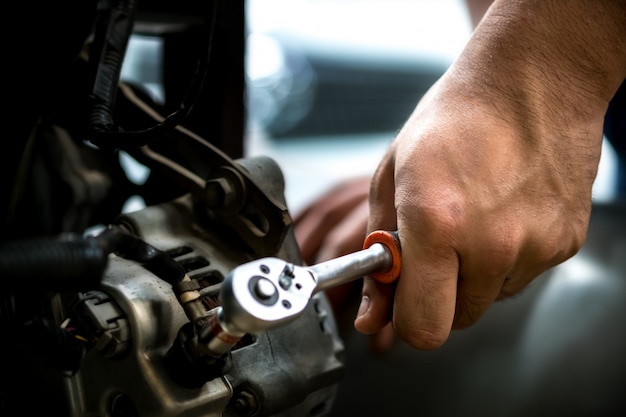 Automonteur met behulp van een moersleutel Dynamo Auto Repair.