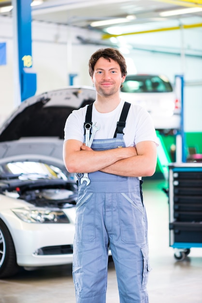 Automonteur reparatie van de motor van een auto in de werkplaats