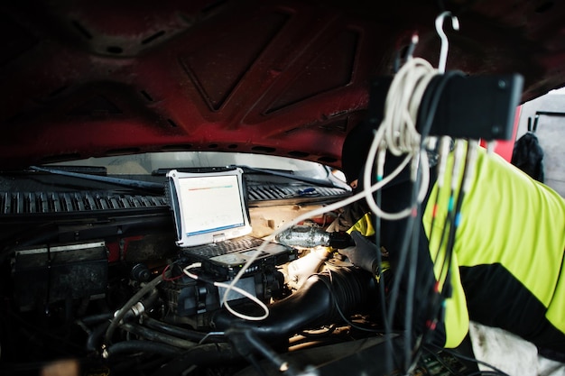 Automonteur stelt Amerikaanse SUV-auto in voor diagnostiek en configuratie in werkplaatstankstation