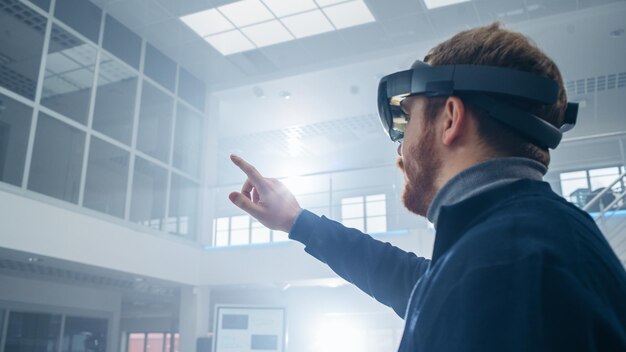 Automotive Engineer Using Augmented Reality Headset and Making Touching Gestures of Virtual Objects in the Air In Innovation High Tech Laboratory Facility with Futuristic Atmosphere