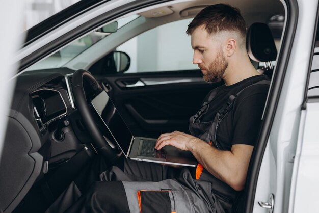 Automotive mechanic running diagnostics software on computer