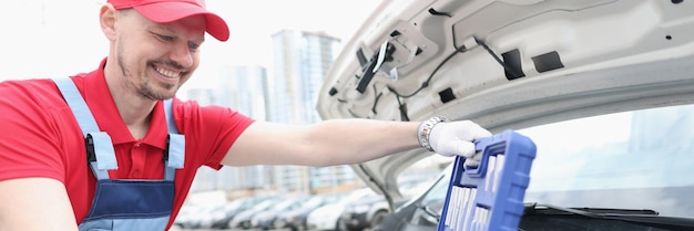 Automotive technician smiling and open kit full of equipments