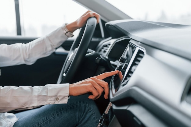 Autorijden Vrouw is overdag in autosalon