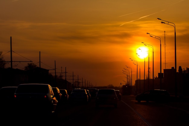 Autoverkeer tegen de zonsondergang achtergrond moderne stad silhouet