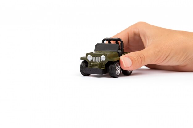 Autoverzekering. Auto miniatuur bedekt door handen.