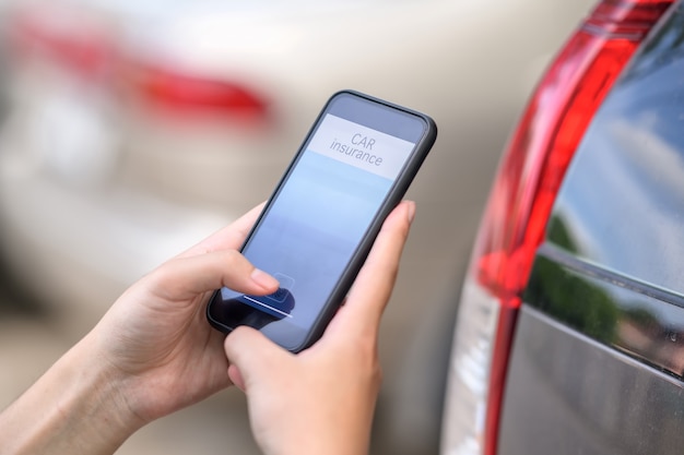 Autoverzekering concept, Man hand met autoverzekering toepassing op mobiele telefoon.