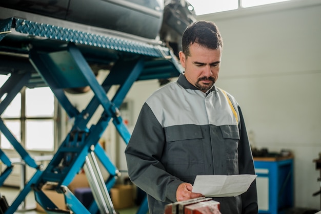 Autowerktuigkundige die de dienstdocument bekijken.