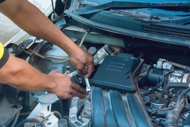 Autowerktuigkundige die met moersleutel in garage werken. Reparatie service.