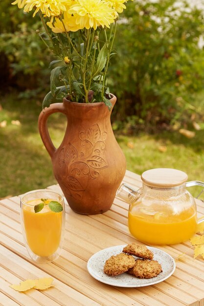 Photo autumn aesthetic breakfast outside healthy tea cup of sea buckthorn tea and vegan pumpkin cookies