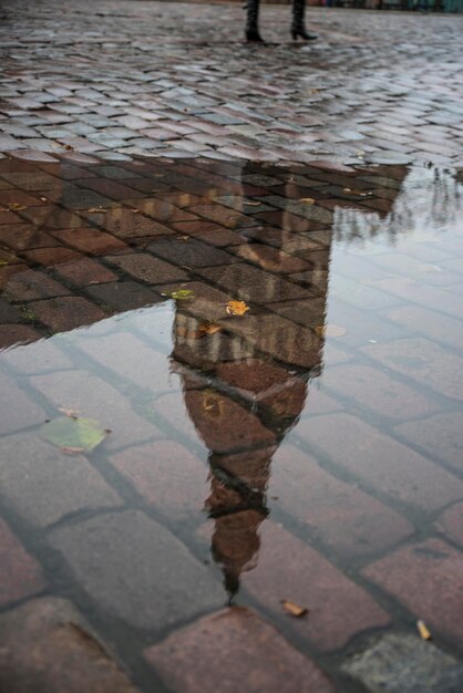 In the autumn after a rain in puddles the buildings are reflected