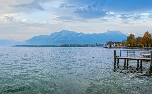 Autumn Alps mountain lake Mondsee misty view Seepromenade Mondsee Salzkammergut Upper Austria People are unrecognizable