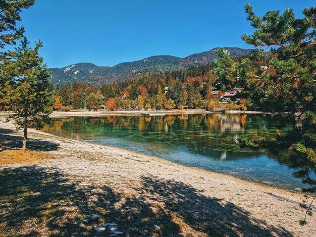 Autumn alps mountains in day light reflected in waters of green lake Jasna, Kranjska Gora. Slovenia