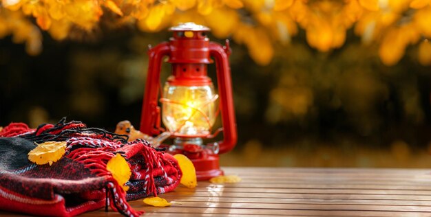 Photo autumn background warm woolen red blanket or plaid lantern decoration autumn leaves on wooden table autumn concept fall background copy space