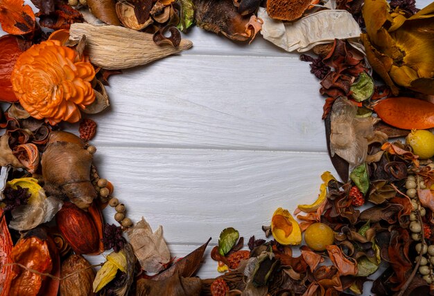 Autumn background where a lot of dry leaves, berries, flowers and nuts are all in a pile