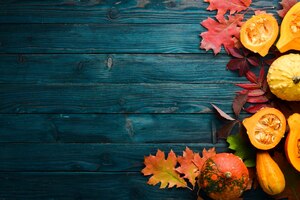 Autumn background with coffee pumpkin autumn leaves flat lay on a blue wooden background top view free space for your text