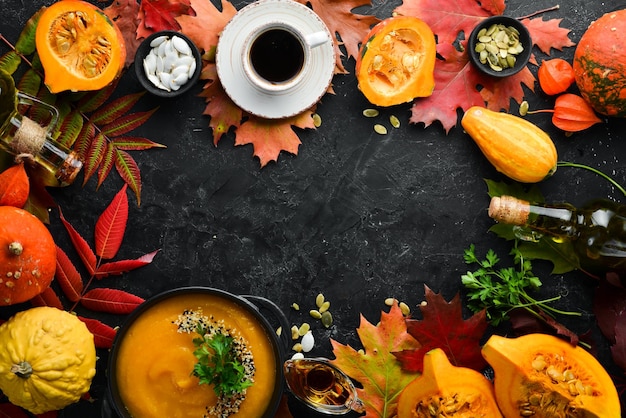 Sfondo autunnale con foglie e semi autunnali di zucca caffè piatto su uno sfondo di pietra nera vista dall'alto spazio libero per il testo