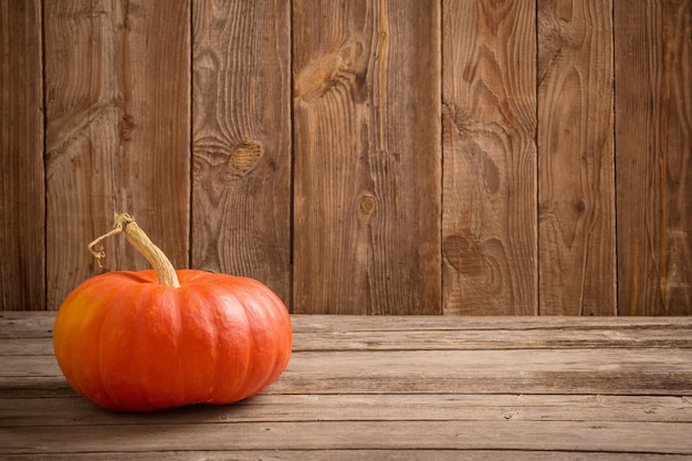 Autumn background with pumpkin on wooden board