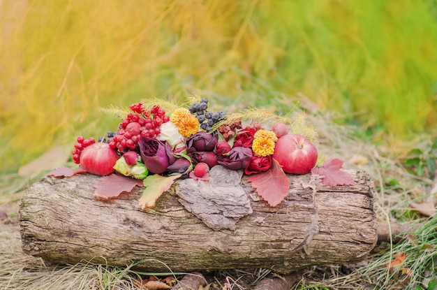 Autumn background with yellow leaves apples and flowers Autumn harvest on wooden background