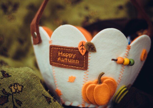 Photo autumn basket of felt with candies on a green background