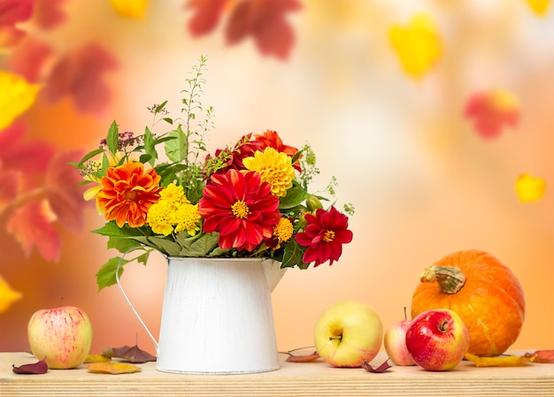 Bouquet autunnale in un vaso e verdure autunnali su uno sfondo sfocato con foglie