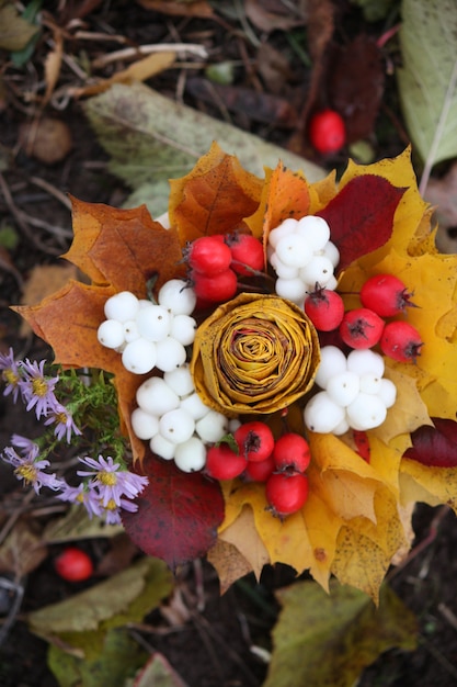 黄色いカエデの葉とスノーベリーの秋の花束