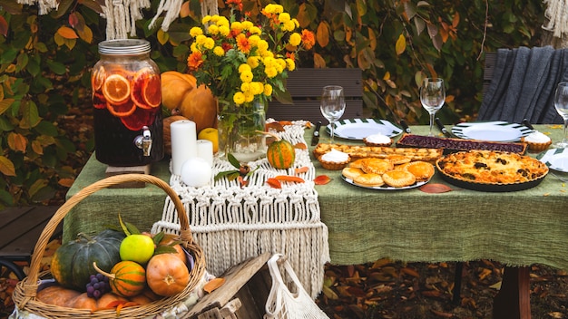 호박과 노란색 장식으로 뒤뜰에있는 가을 브런치 테이블.