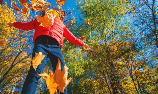 Autumn child in the park with yellow leaves Selective focus Kid