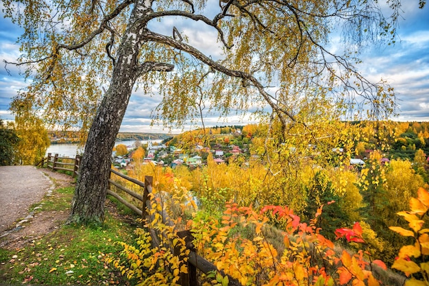 Autumn city Plyos from the height of the Cathedral Mountain behind a wooden fence houses