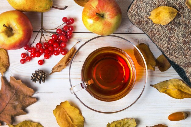 Autumn clothes and a cup of tea on a wooden background