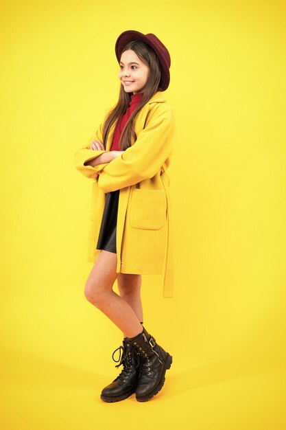 Autumn clothes full length of cheerful teenager child girl\
wearing comfy trendy fashion clothes isolated over yellow\
background happy teenager portrait smiling girl