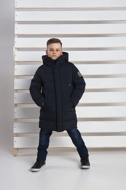 Autumn collection of clothes for children and teenagers. Jackets and coats for autumn cold weather. Children pose on a white background. 