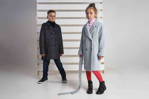 Autumn collection of clothes for children and teenagers. Jackets and coats for autumn cold weather. Children pose 