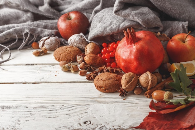 Foto composizione autunnale di foglie di autunno frutti e spezie su un tavolo di legno bianco