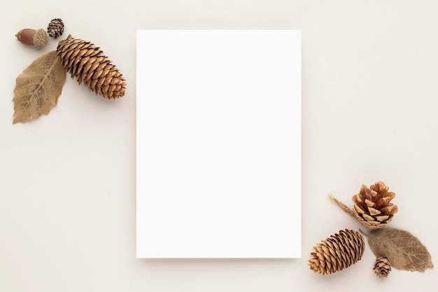 Photo autumn composition blank paper cards mockup with dried leaves  and pine cones on beige background fl...