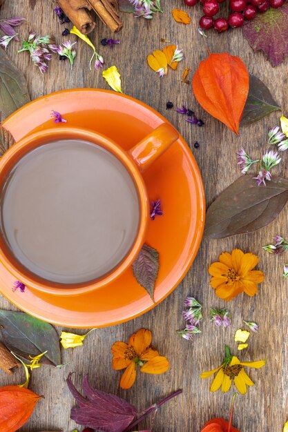 花と葉のトップビューの背景画像とテーブルの上のコーヒーの秋の構成カップ