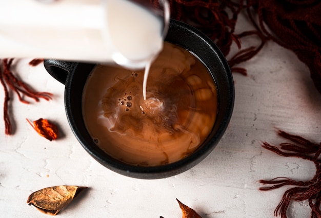 Autumn composition. A cup of coffee with milk, a woman's sweater, autumn leaves. Flat lay, top view, copy space. High quality photo