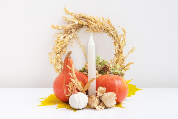 Autumn composition dried leaves pumpkins and candles on white background autumn fall and thanksgivin
