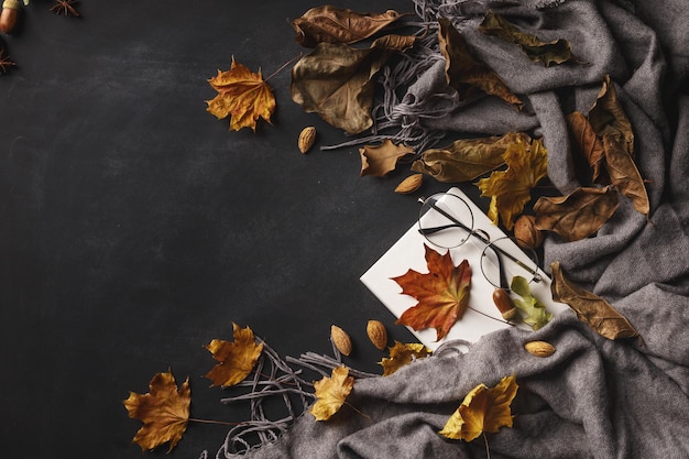 Foto composizione autunnale di foglie e frutti secchi su sfondo scuro vista dall'alto spazio di copia