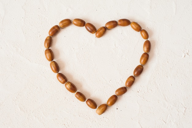 Autumn composition. Frame made of acorn in the shape of heart